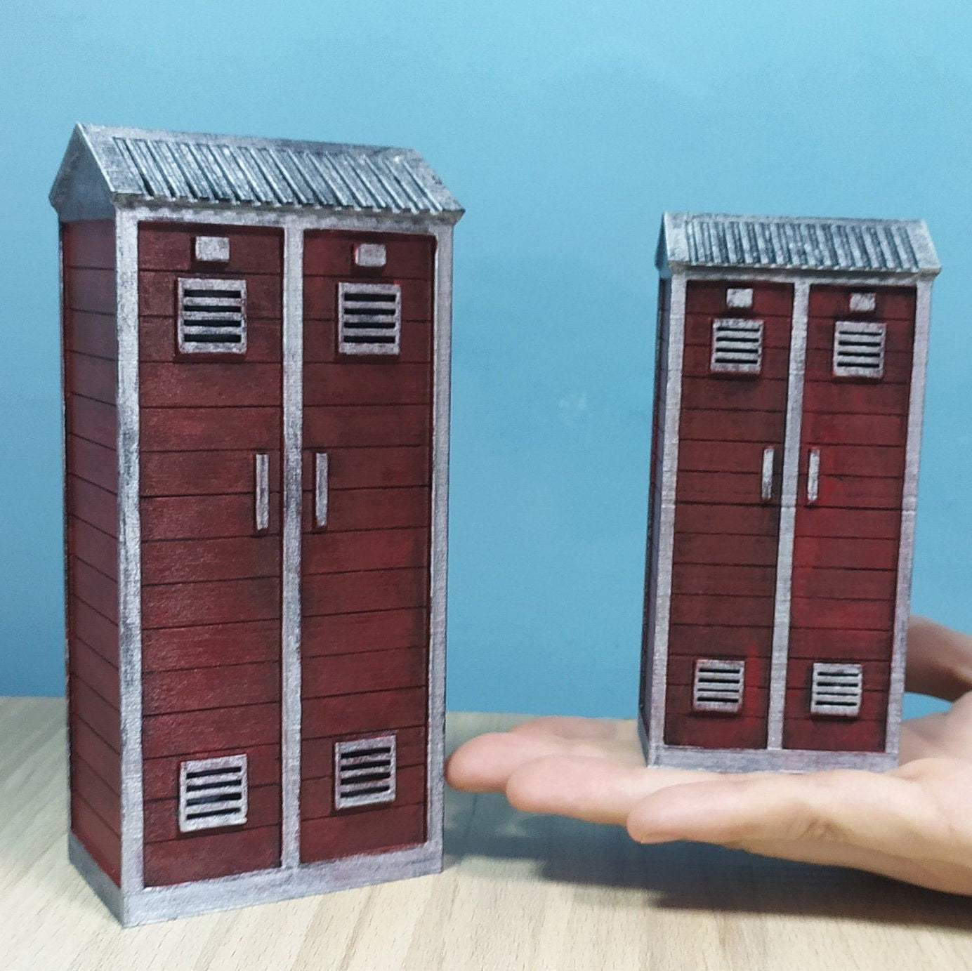 Two miniature red lockers on a hand against a blue background