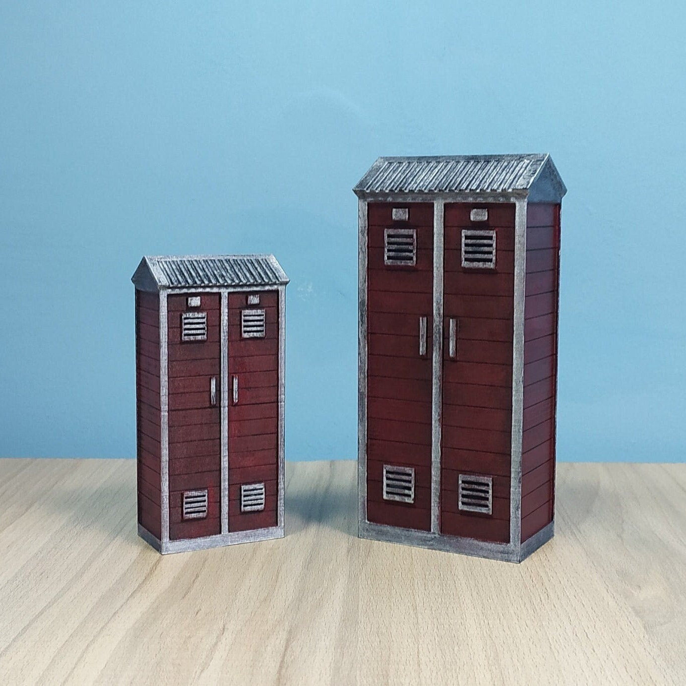 Two model lockers on a wooden surface with a blue background