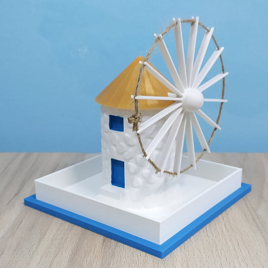 Model of a Greek windmill Planter on a wooden surface with a blue background