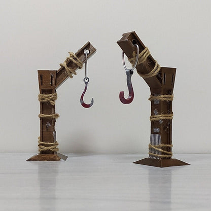 Two rusted metal armatures with hooks on a white background