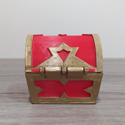 Red and gold treasure chest on a wooden surface with a light gray background
