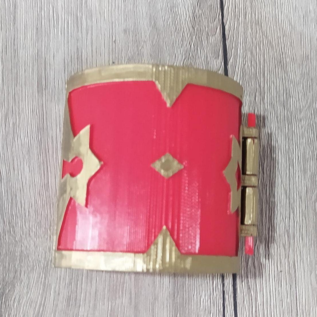 Red and gold bracelet on a wooden surface