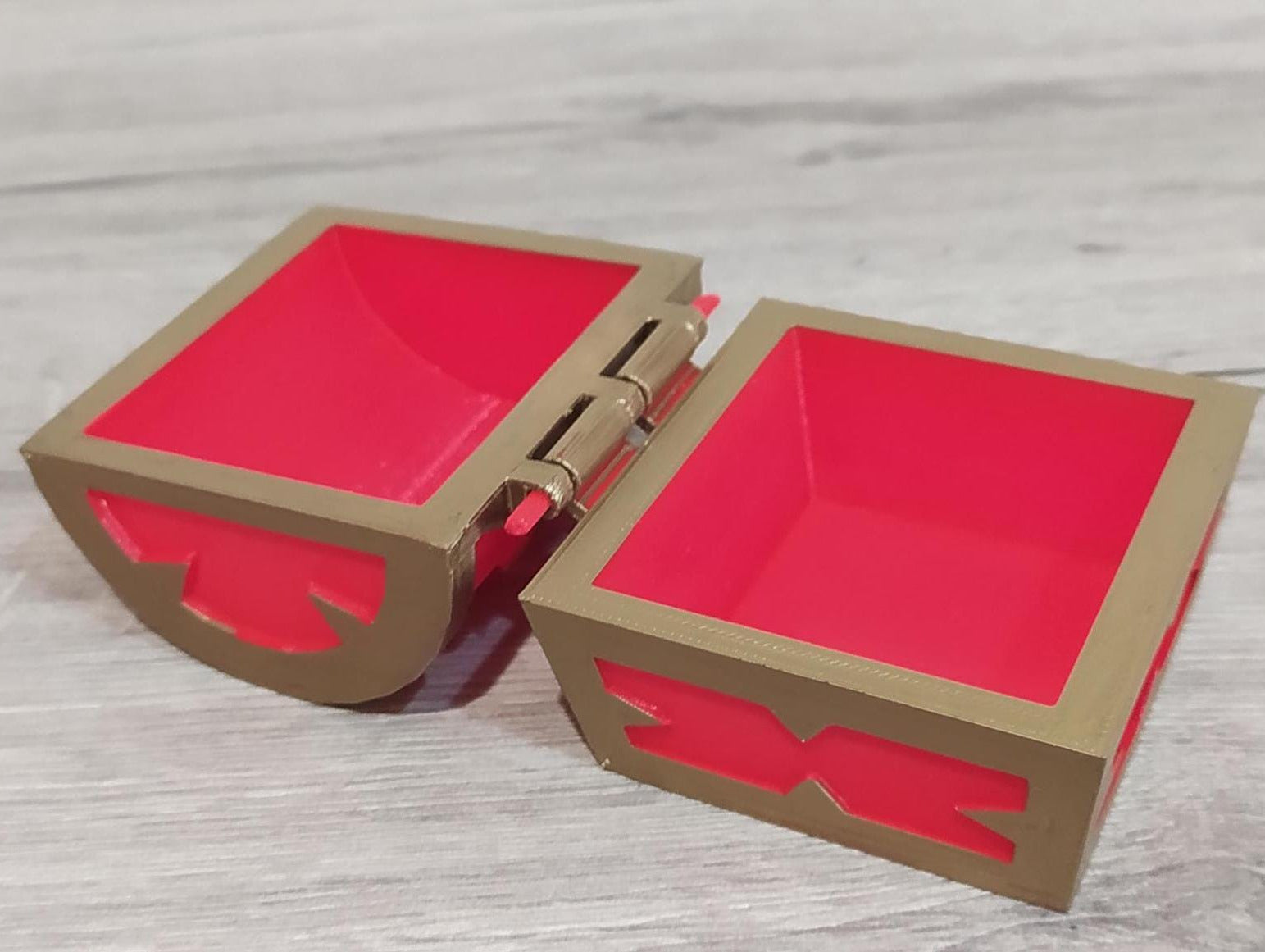 Red and gold jewelry box on a light wooden surface